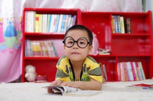 KID WITH glasses reading
